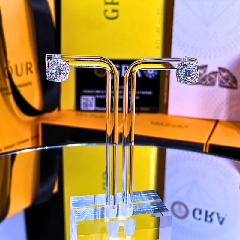 Brilliant cushion-cut moissanite with sparkling halo setting in sterling silver. Timeless elegance and exceptional fire make these studs perfect for everyday sophistication.