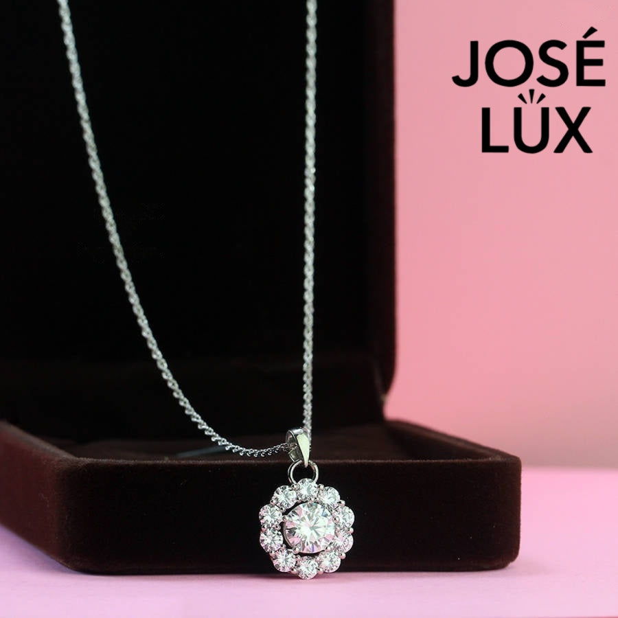 Timeless round moissanite pendant surrounded by scalloped halo design creates vintage-inspired elegance, expertly handcrafted in lustrous sterling silver for lasting beauty.