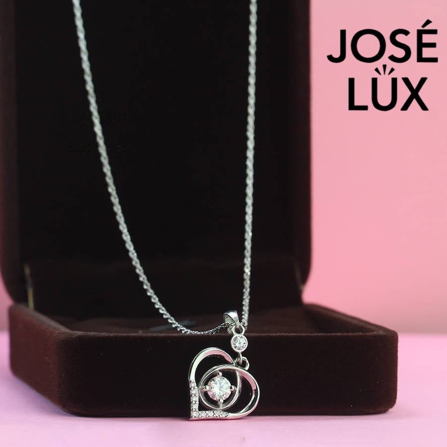 Heartfelt 0.5ct round moissanite dancing heart pendant features floating center stone within layered heart design, tenderly crafted in polished sterling silver