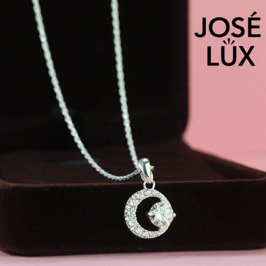 Mystical 0.8ct round moissanite crescent moon pendant captures celestial beauty with pavé-set moon frame, elegantly fashioned in lustrous sterling silver.