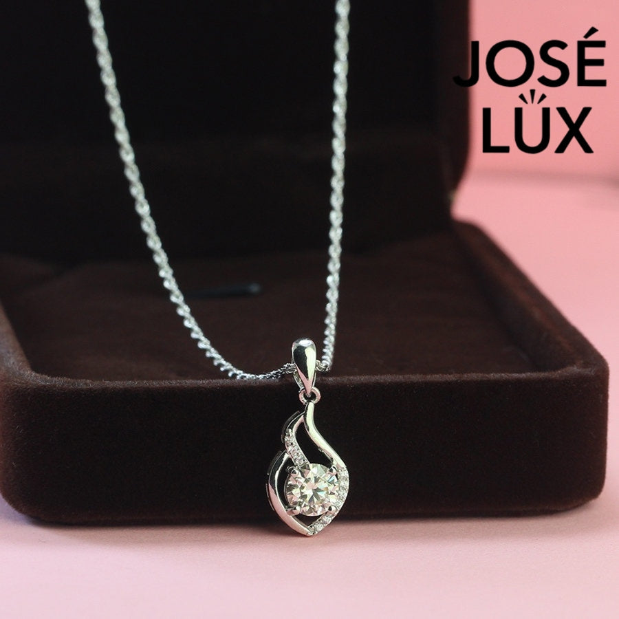 Graceful 0.8ct round moissanite flame swirl pendant features flowing curved design with pavé accents, creating dynamic movement in quality sterling silver craftsmanship.