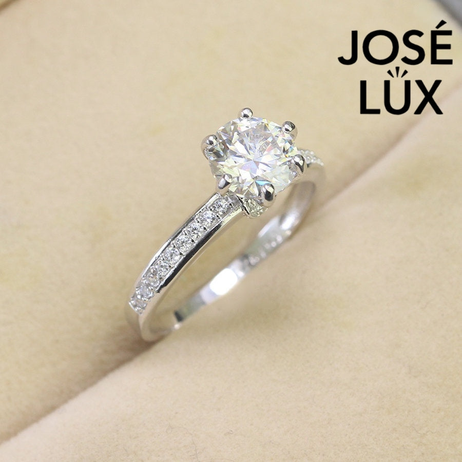 Classic solitaire design featuring brilliant 1.25ct moissanite and complementary accent stones beautifully showcased in sterling silver setting.