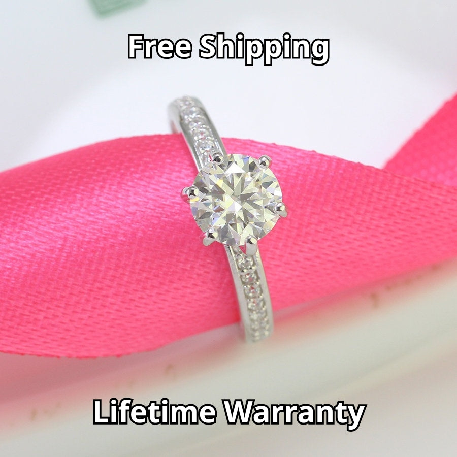 Classic solitaire design featuring brilliant 1.25ct moissanite and complementary accent stones beautifully showcased in sterling silver setting.