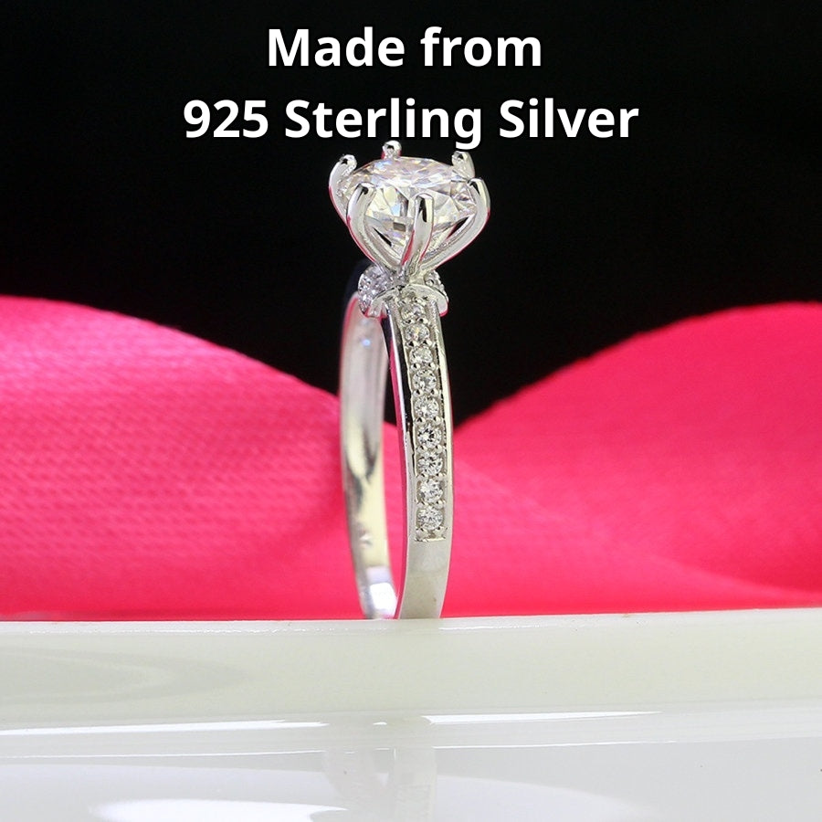 Classic solitaire design featuring brilliant 1.25ct moissanite and complementary accent stones beautifully showcased in sterling silver setting.