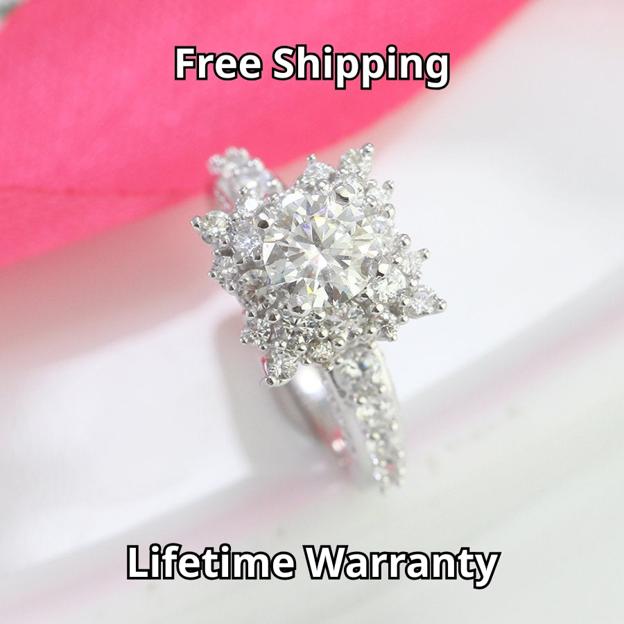 Vintage-inspired art deco design features brilliant round moissanite surrounded by sparkling halo accents on a delicate pavé band.