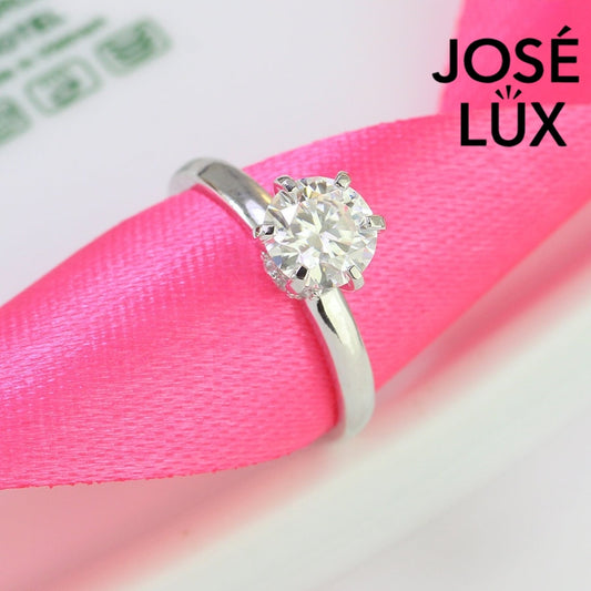 Traditional solitaire setting highlights brilliant round moissanite on a sleek silver band for timeless sophistication and everyday wearability.