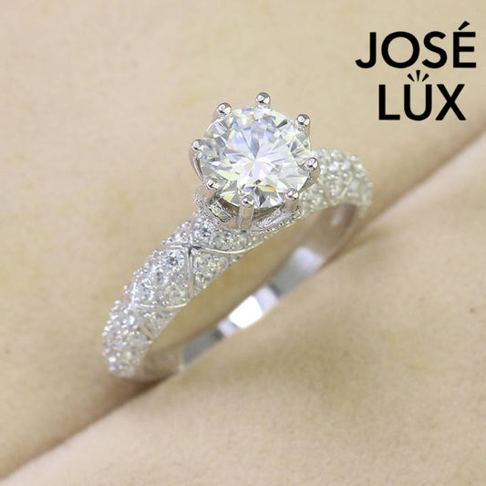 Elegant cathedral setting showcases brilliant round moissanite with sparkling pavé accents along the band for timeless sophistication and style.