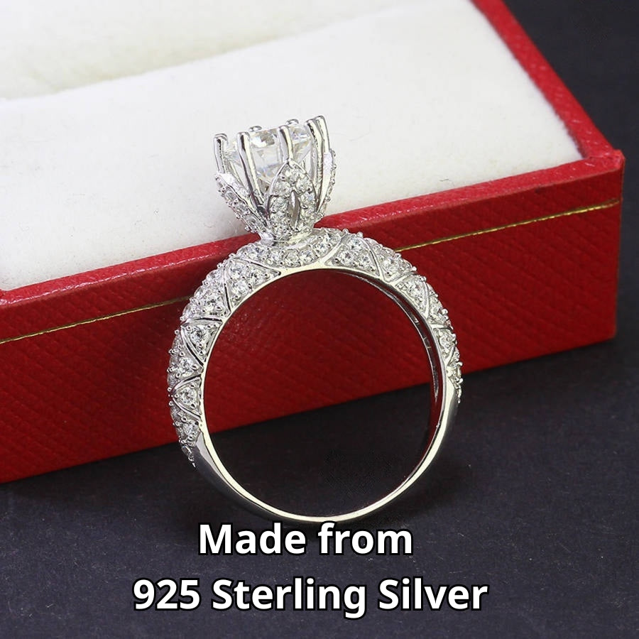 Elegant cathedral setting showcases brilliant round moissanite with sparkling pavé accents along the band for timeless sophistication and style.