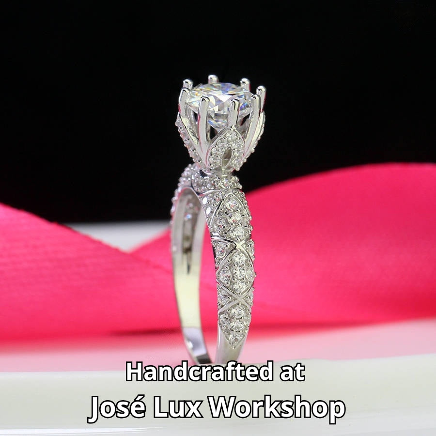 Elegant cathedral setting showcases brilliant round moissanite with sparkling pavé accents along the band for timeless sophistication and style.