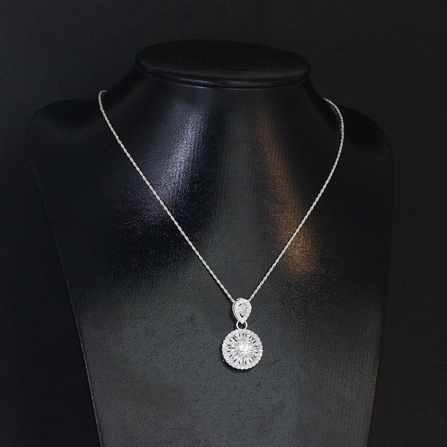 Sophisticated 1.2ct moissanite pendant features elegant teardrop and round halo design, creating stunning layered brilliance in beautifully crafted sterling silver jewelry