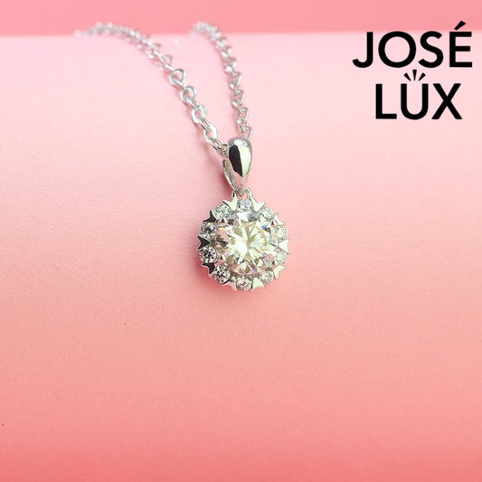 Romantic 1.2ct round moissanite heart halo pendant showcases brilliant center stone within pavé-set heart frame, lovingly handcrafted in gleaming sterling silver.