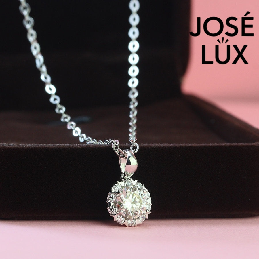 Romantic 1.2ct round moissanite heart halo pendant showcases brilliant center stone within pavé-set heart frame, lovingly handcrafted in gleaming sterling silver.