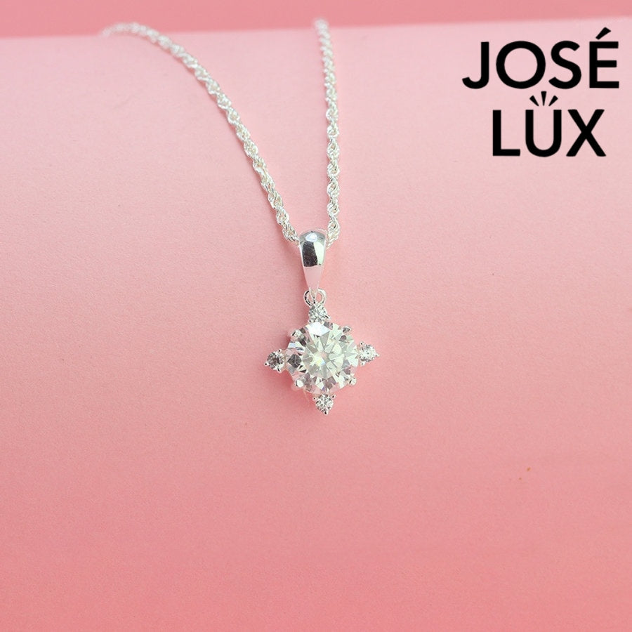 Celestial 1.2ct round moissanite four point star pendant radiates brilliance with triangular accent stones, creating stunning symmetry in sterling silver jewelry.