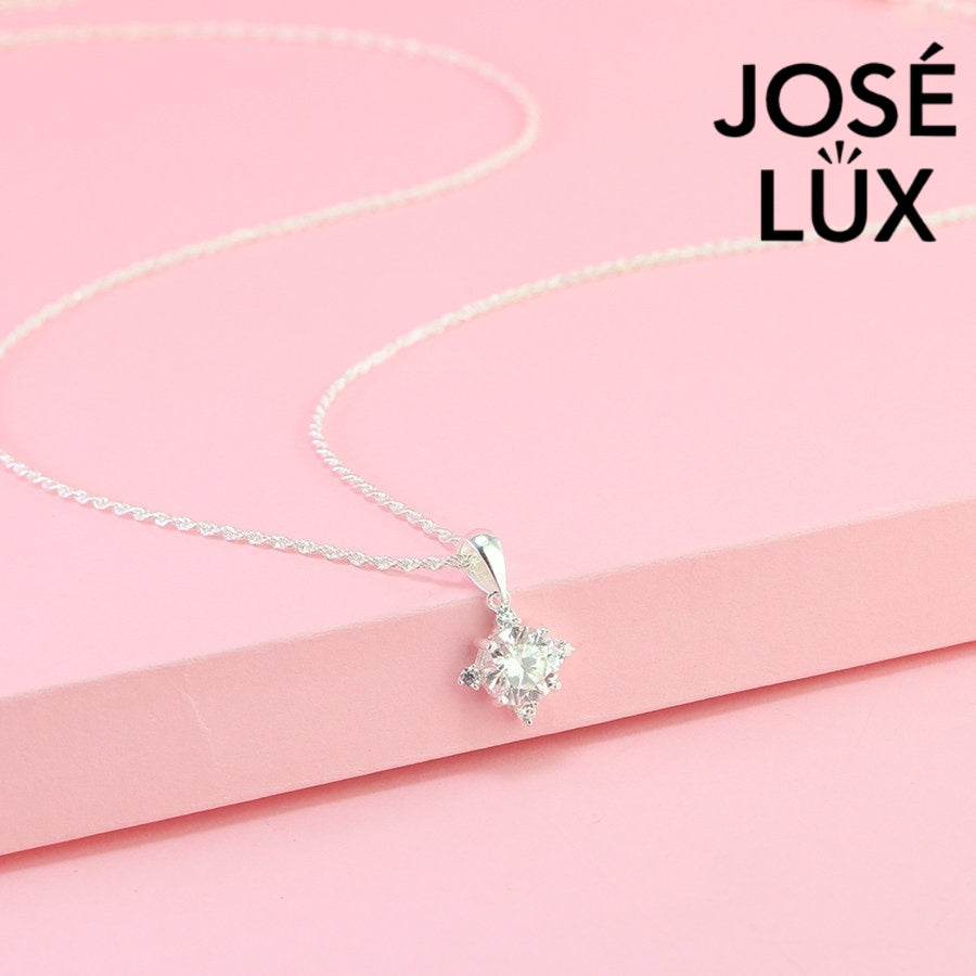 Celestial 1.2ct round moissanite four point star pendant radiates brilliance with triangular accent stones, creating stunning symmetry in sterling silver jewelry.