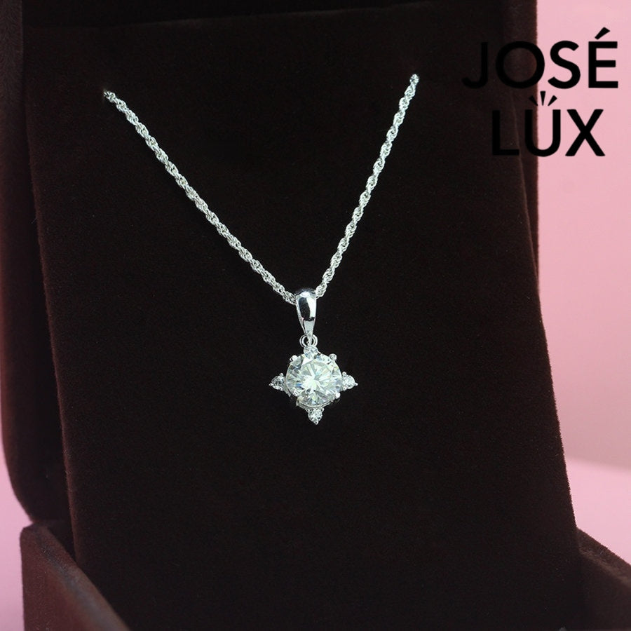 Celestial 1.2ct round moissanite four point star pendant radiates brilliance with triangular accent stones, creating stunning symmetry in sterling silver jewelry.