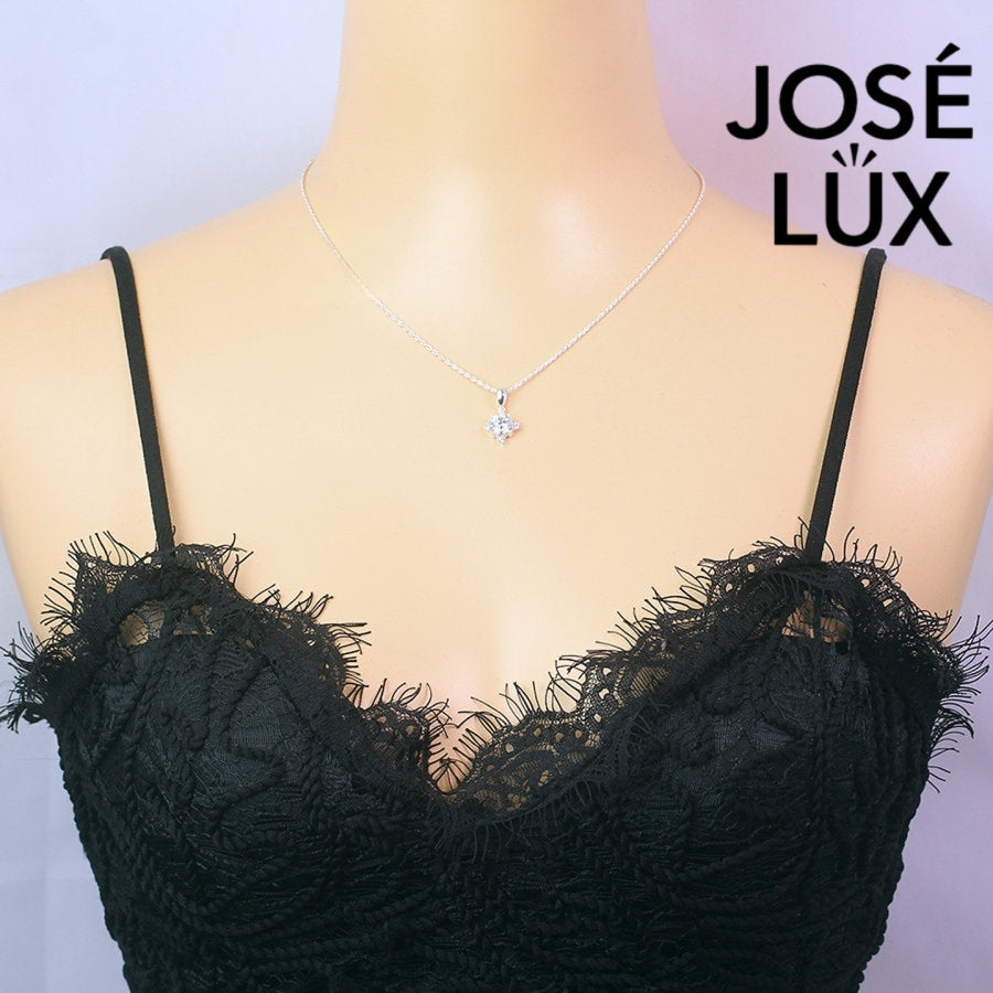 Celestial 1.2ct round moissanite four point star pendant radiates brilliance with triangular accent stones, creating stunning symmetry in sterling silver jewelry.