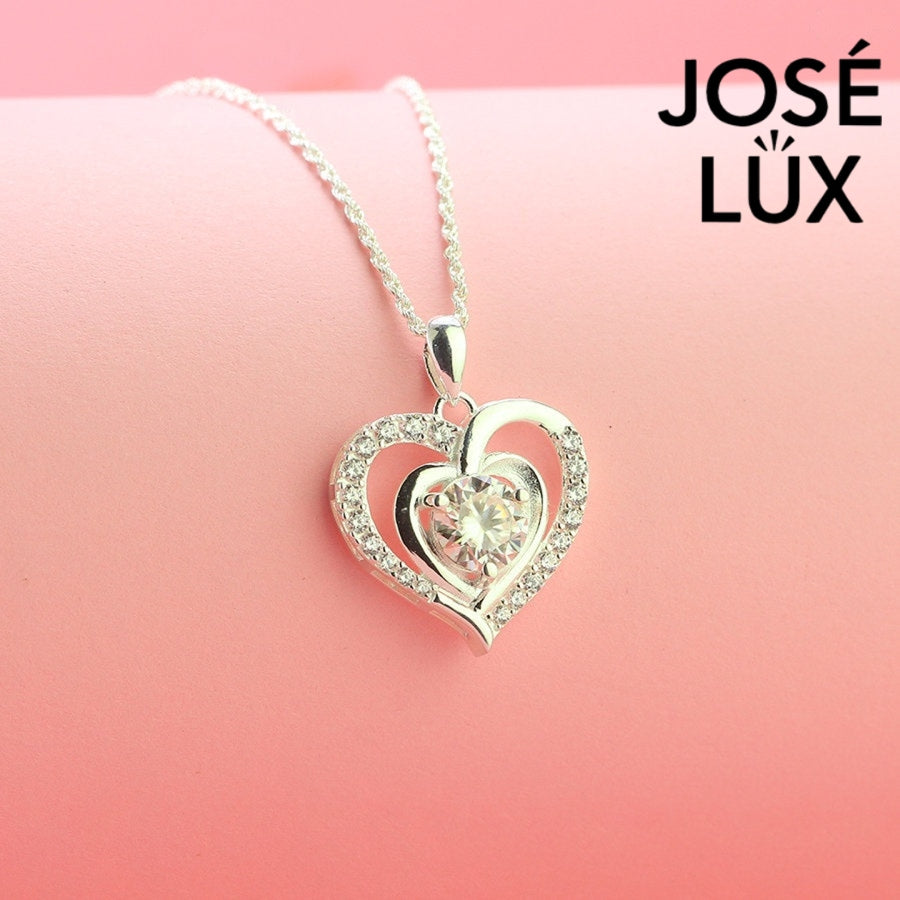 Romantic 1.2ct round moissanite heart halo pendant showcases brilliant center stone within pavé-set heart frame, lovingly handcrafted in gleaming sterling silver.