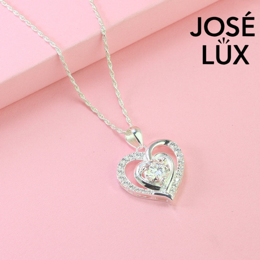 Romantic 1.2ct round moissanite heart halo pendant showcases brilliant center stone within pavé-set heart frame, lovingly handcrafted in gleaming sterling silver.