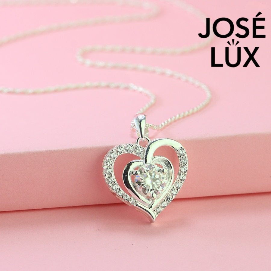 Romantic 1.2ct round moissanite heart halo pendant showcases brilliant center stone within pavé-set heart frame, lovingly handcrafted in gleaming sterling silver.