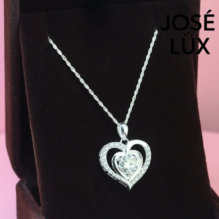 Romantic 1.2ct round moissanite heart halo pendant showcases brilliant center stone within pavé-set heart frame, lovingly handcrafted in gleaming sterling silver.