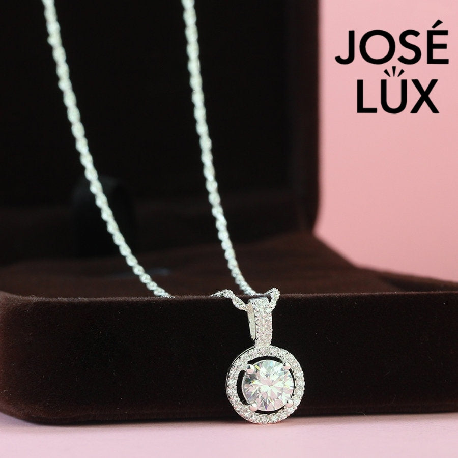 Luxurious 1.2ct round moissanite pavé bail halo pendant displays maximum sparkle with stone-set connector and surrounding halo, skillfully set in sterling silver.