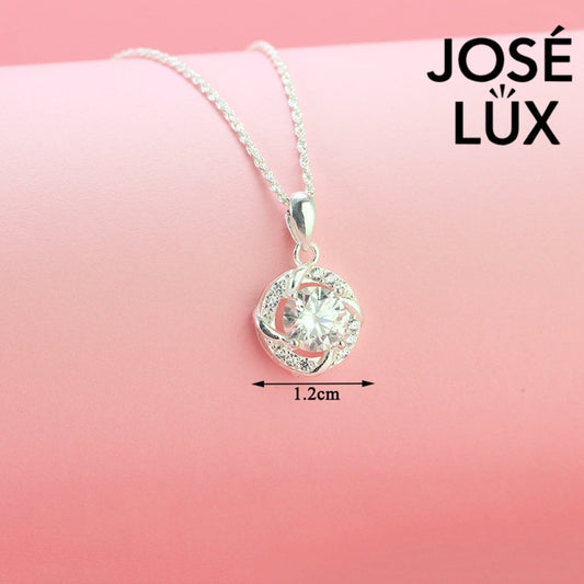 Intricate 1.2ct round moissanite twisted knot halo pendant showcases stunning center stone within pavé-accented interwoven design, artfully created in polished sterling silver.