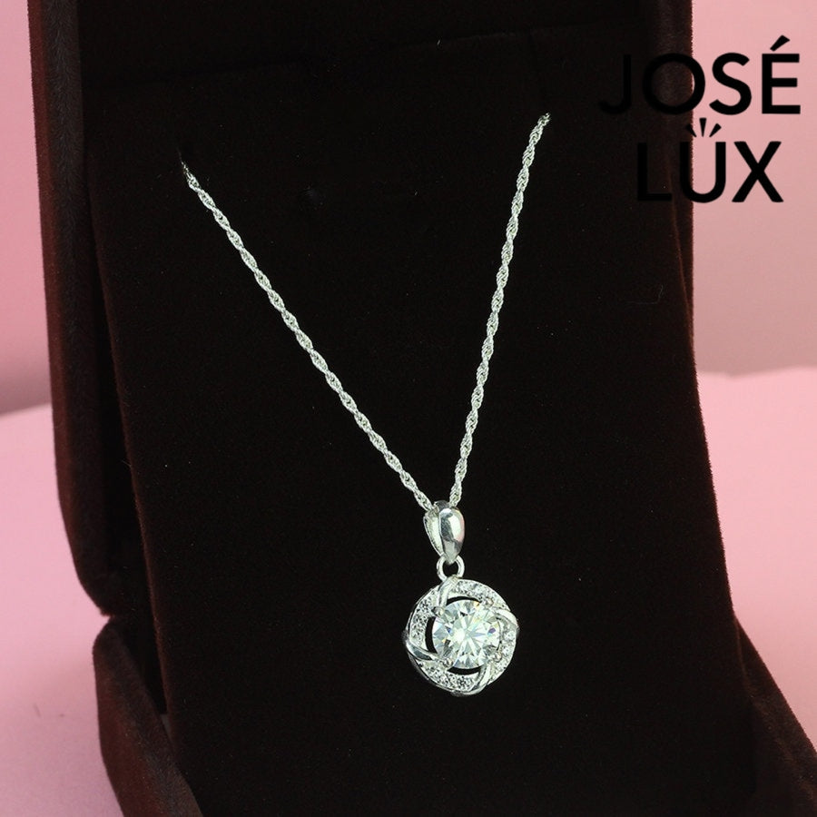 Intricate 1.2ct round moissanite twisted knot halo pendant showcases stunning center stone within pavé-accented interwoven design, artfully created in polished sterling silver.