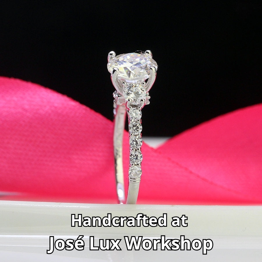 Brilliant 1.5ct moissanite center stone with sparkling side accents set in polished sterling silver creates timeless elegance for any occasion.