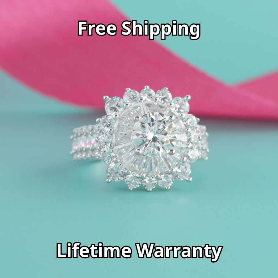 Stunning sunburst design features brilliant round moissanite surrounded by baguette and round accent stones with sparkling pavé band detailing.