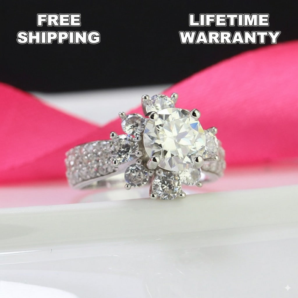 Stunning 2ct moissanite center stone surrounded by brilliant halo accents in a classic cluster design, beautifully crafted in sterling silver.