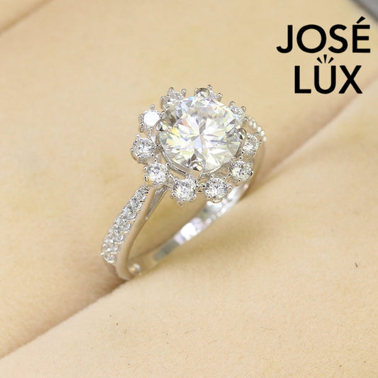 Elegant 2ct moissanite center stone surrounded by sparkling halo diamonds on a pavé silver band. Classic design perfect for special occasions and everyday elegance.