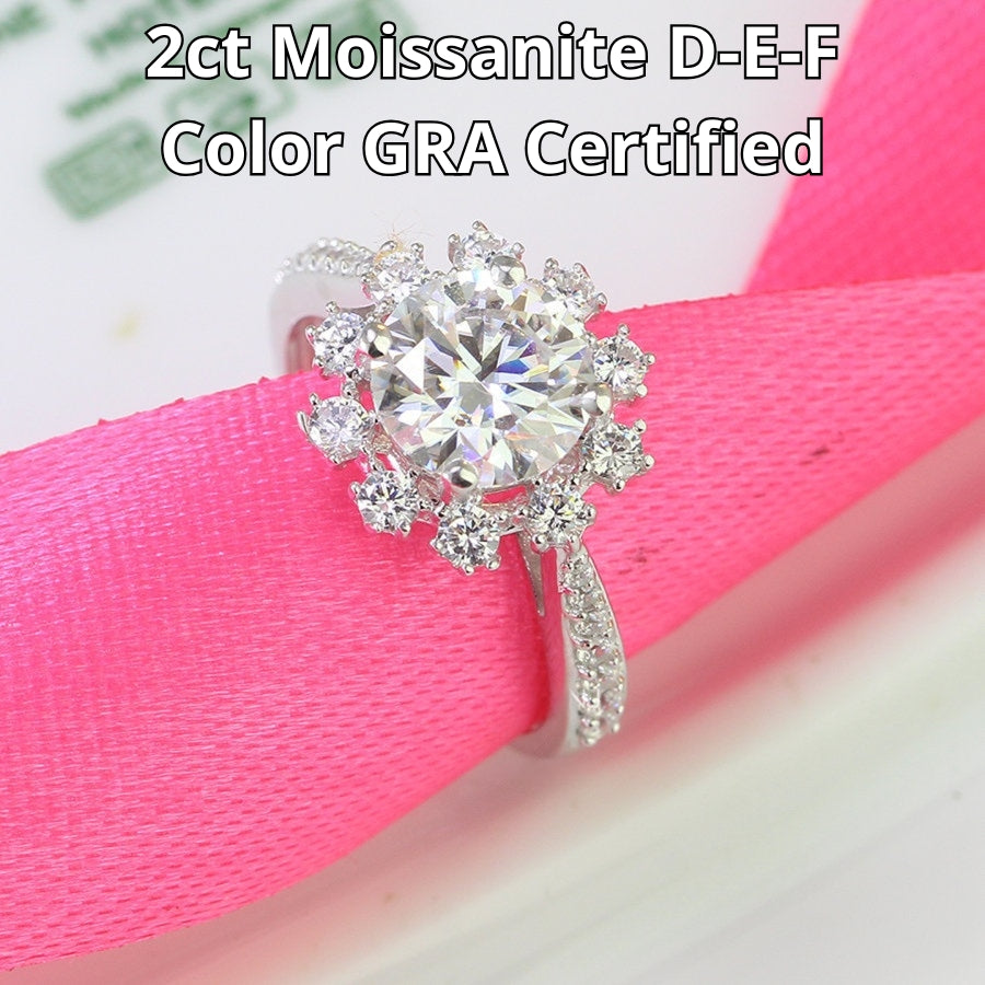 Elegant 2ct moissanite center stone surrounded by sparkling halo diamonds on a pavé silver band. Classic design perfect for special occasions and everyday elegance.