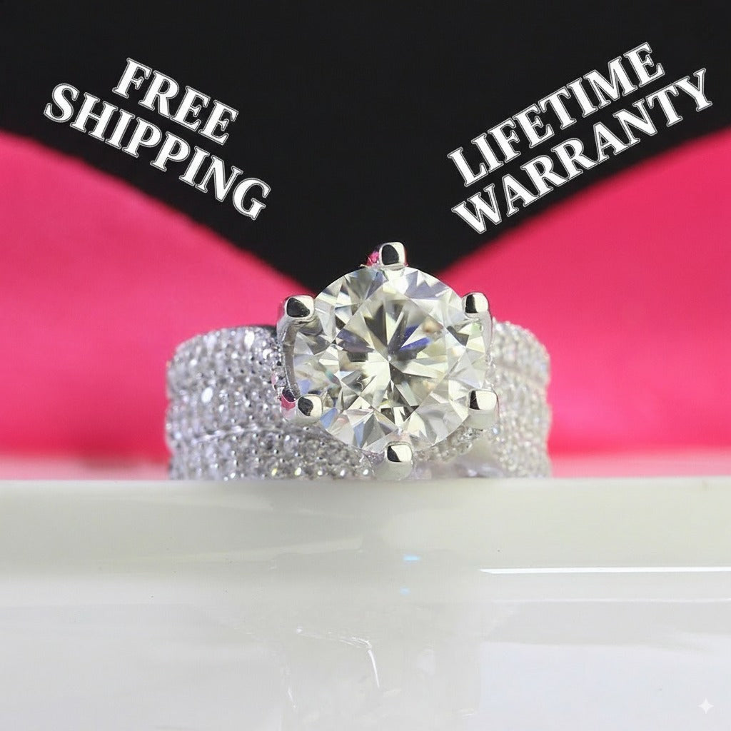 Brilliant 4ct round moissanite centerpiece showcased in sterling silver with sparkling pavé band. Classic design features exceptional fire and brilliance for timeless elegance.