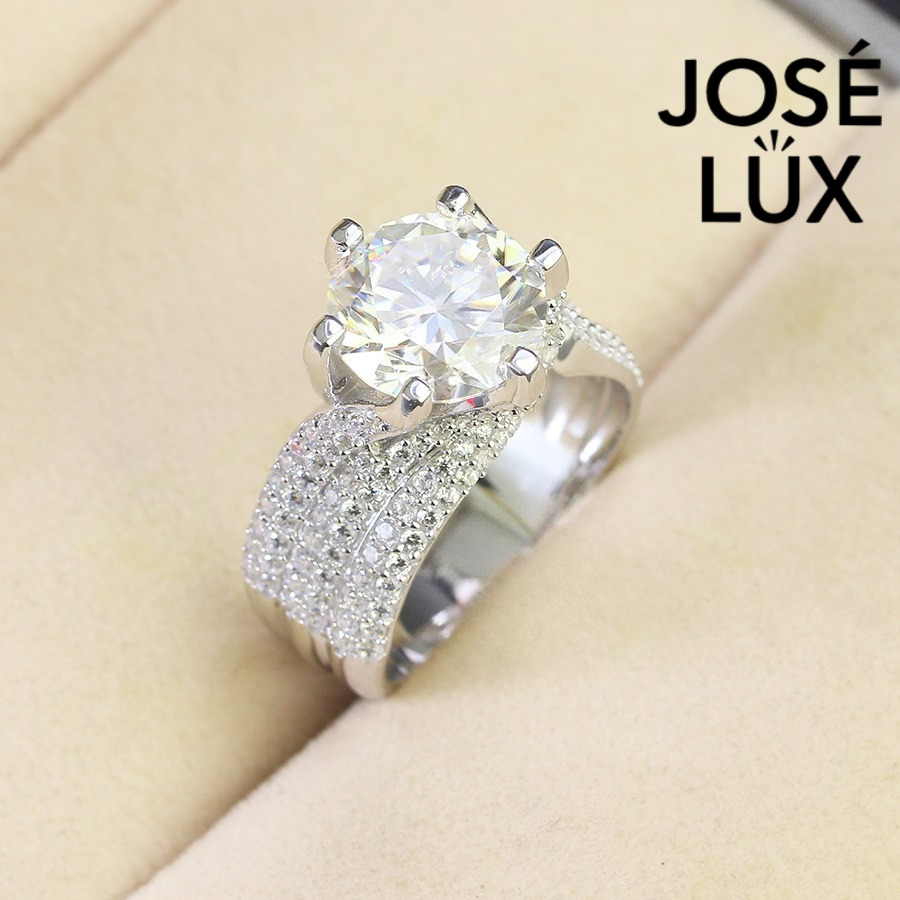 Brilliant 4ct round moissanite centerpiece showcased in sterling silver with sparkling pavé band. Classic design features exceptional fire and brilliance for timeless elegance.