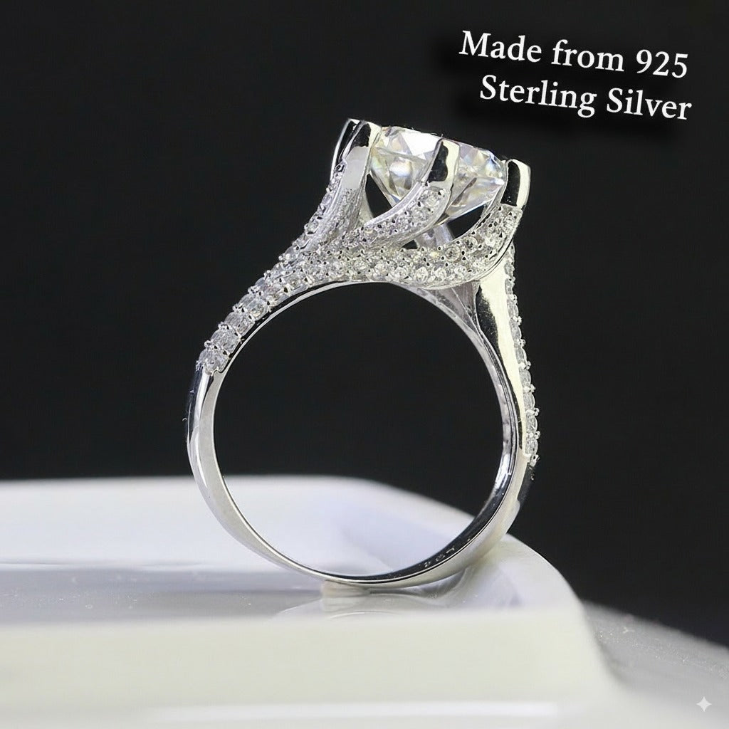 Brilliant 4ct round moissanite centerpiece showcased in sterling silver with sparkling pavé band. Classic design features exceptional fire and brilliance for timeless elegance.