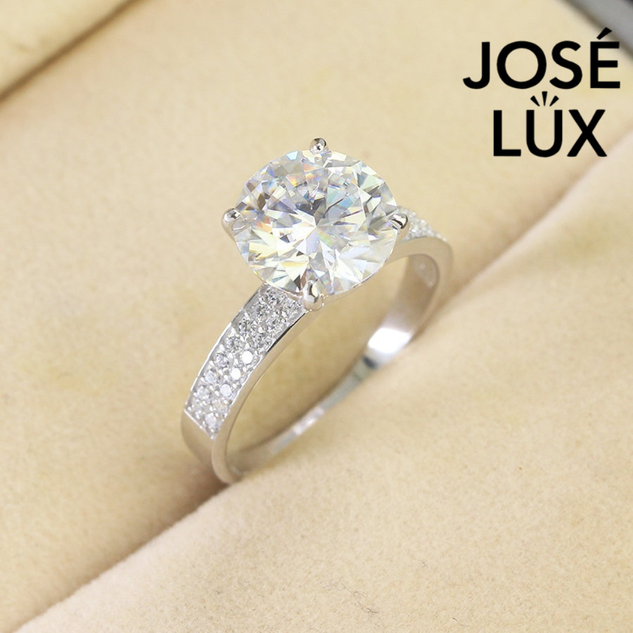 Elegant 4ct round moissanite solitaire ring featuring brilliant sparkle and pavé diamond accents on a polished sterling silver band for timeless sophistication.