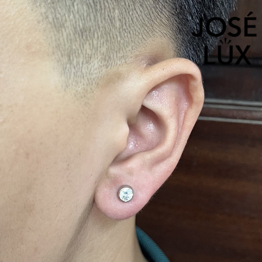 Sterling silver 0.5ct moissanite stud earring worn by man, showcasing low-profile bezel setting for modern, everyday style.