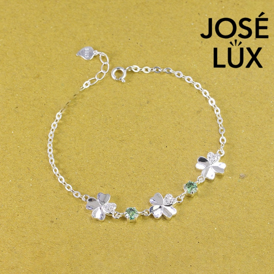 Clover link green moissanite bracelet in sterling silver displays three four-leaf motifs connected by brilliant green stones totaling 0.6 carats.