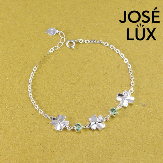 Clover link green moissanite bracelet in sterling silver displays three four-leaf motifs connected by brilliant green stones totaling 0.6 carats.
