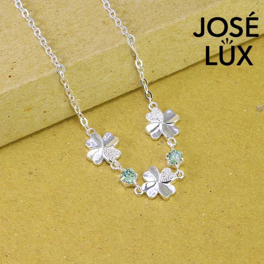 Clover link green moissanite bracelet in sterling silver displays three four-leaf motifs connected by brilliant green stones totaling 0.6 carats.