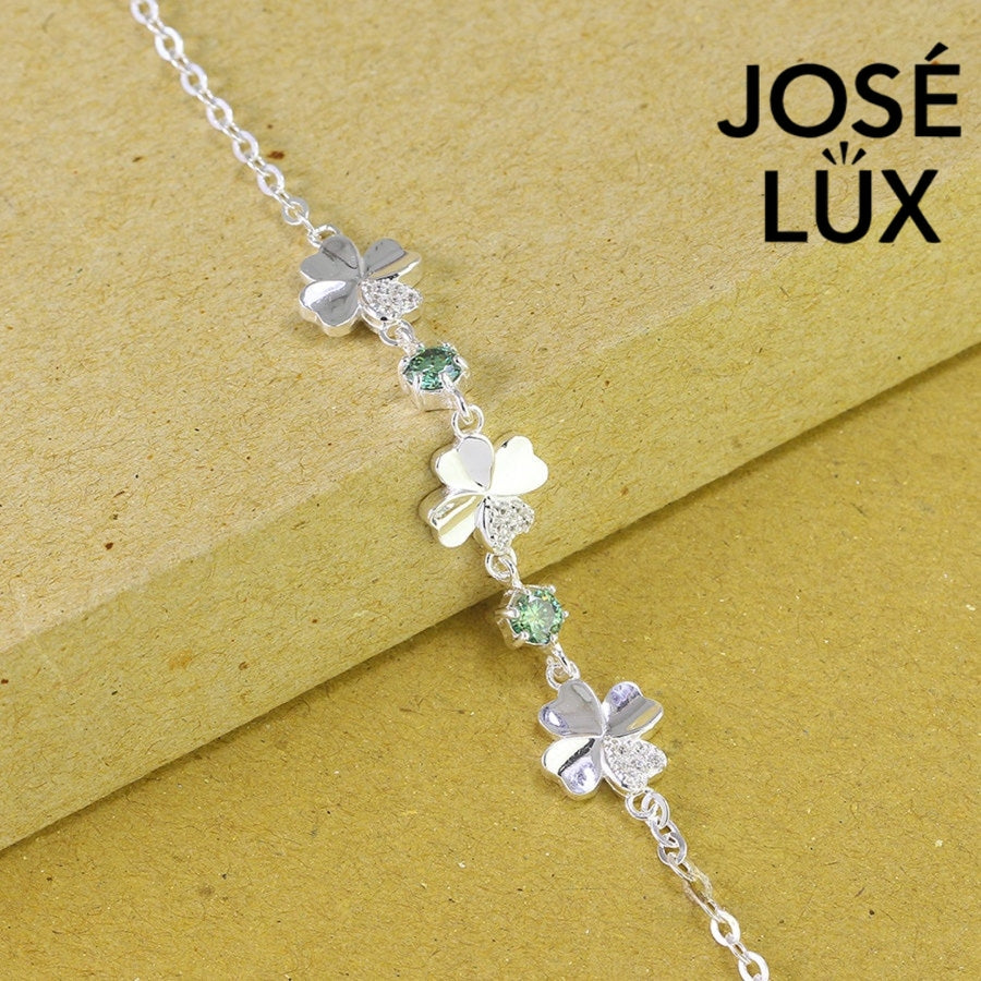 Clover link green moissanite bracelet in sterling silver displays three four-leaf motifs connected by brilliant green stones totaling 0.6 carats.