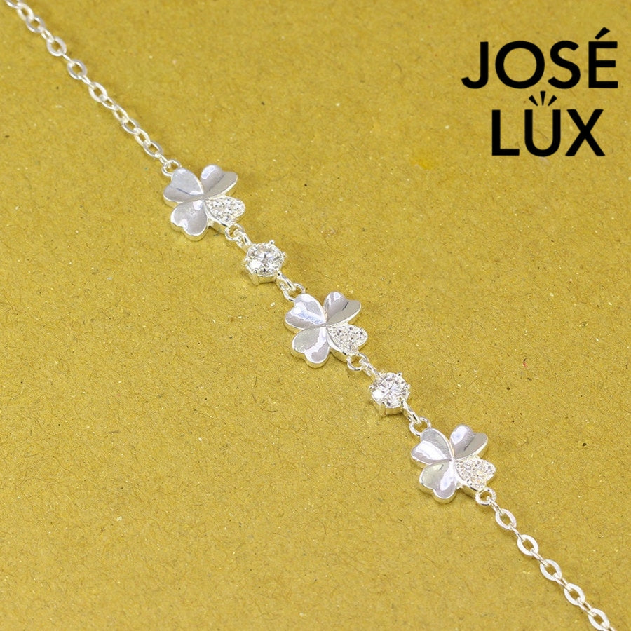 Flower station cable moissanite bracelet in sterling silver features three botanical motifs with brilliant stones totaling 0.6 carats on adjustable chain design.