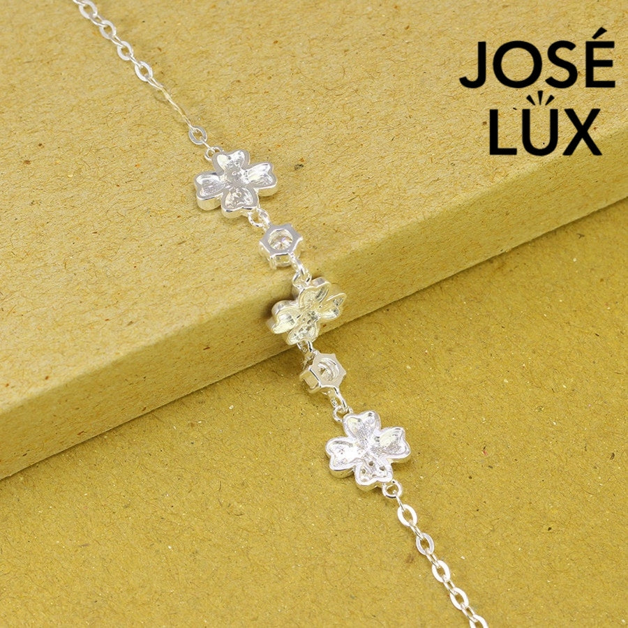 Flower station cable moissanite bracelet in sterling silver features three botanical motifs with brilliant stones totaling 0.6 carats on adjustable chain design.