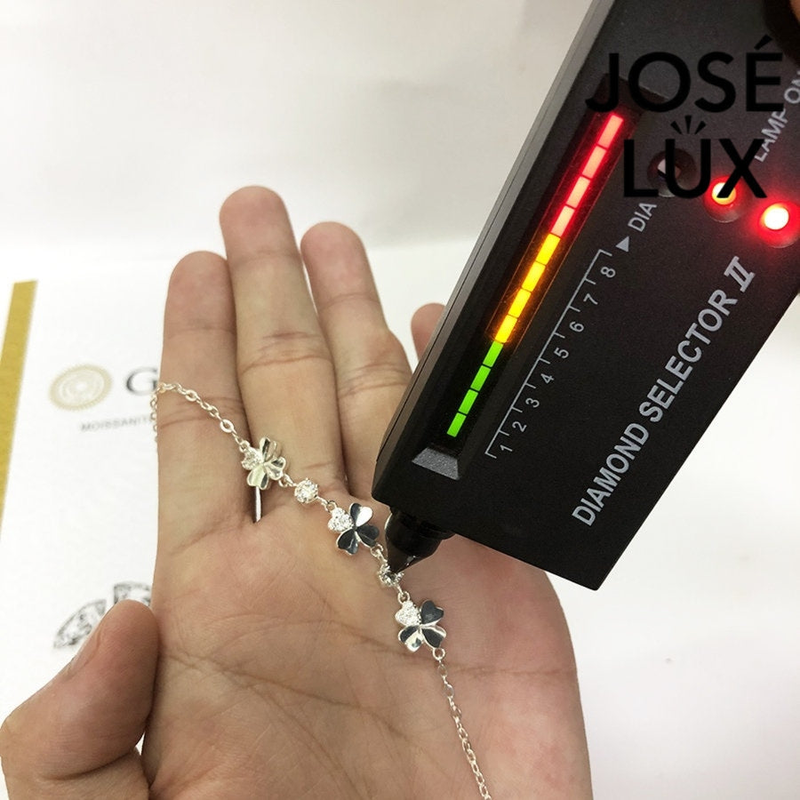 Flower station cable moissanite bracelet in sterling silver features three botanical motifs with brilliant stones totaling 0.6 carats on adjustable chain design.