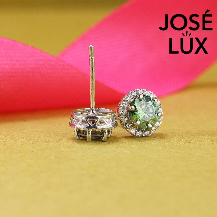 Stunning green moissanite with sparkling halo setting in sterling silver. Vibrant color and brilliant fire create captivating elegance for sophisticated everyday wear.