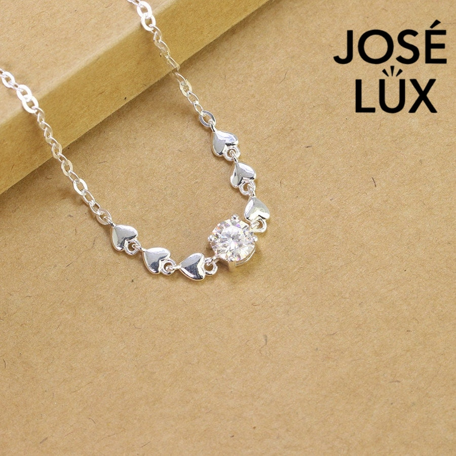 Heart chain solitaire moissanite bracelet in sterling silver showcases six romantic heart motifs with brilliant centerpiece stone weighing 0.8 carats on cable chain.