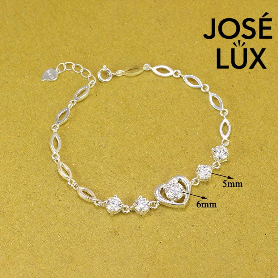 Heart motif moissanite bracelet crafted in sterling silver features five brilliant stones totaling 2.02 carats with elegant oval link chain design.