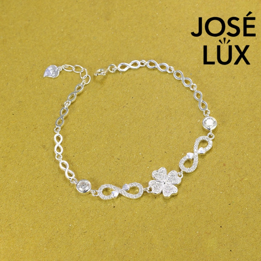 Infinity link moissanite bracelet in sterling silver showcases clover centerpiece with two brilliant stones totaling 0.68 carats on symbolic endless chain design.