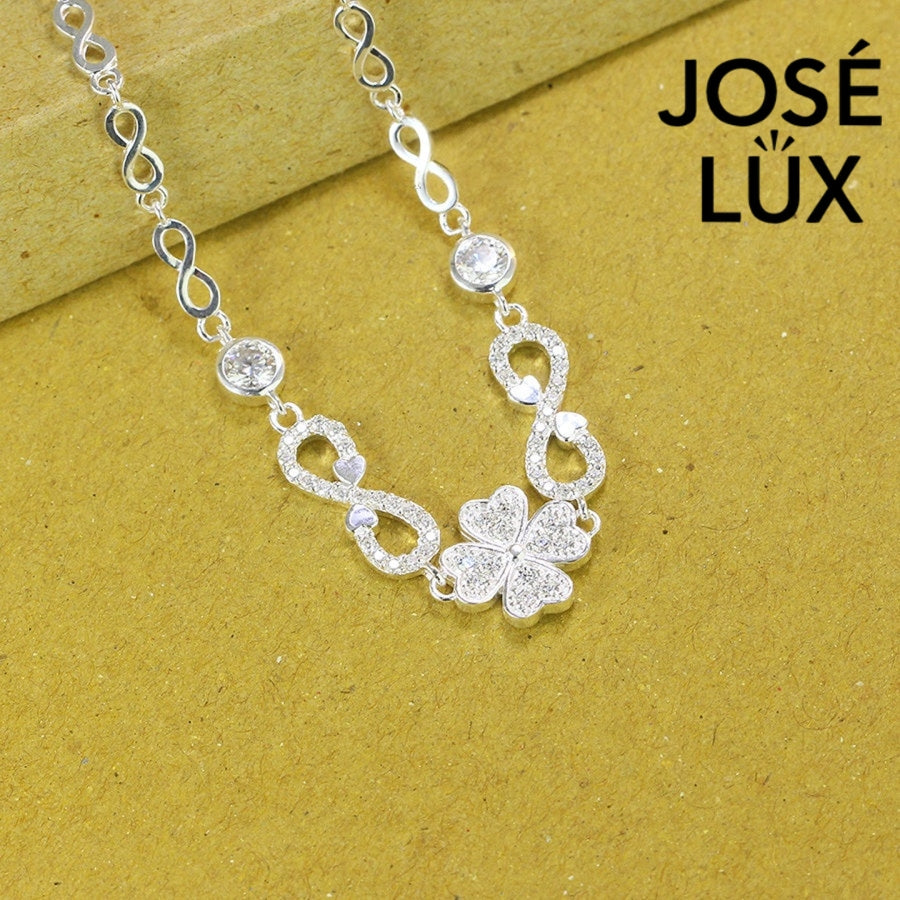 Infinity link moissanite bracelet in sterling silver showcases clover centerpiece with two brilliant stones totaling 0.68 carats on symbolic endless chain design.