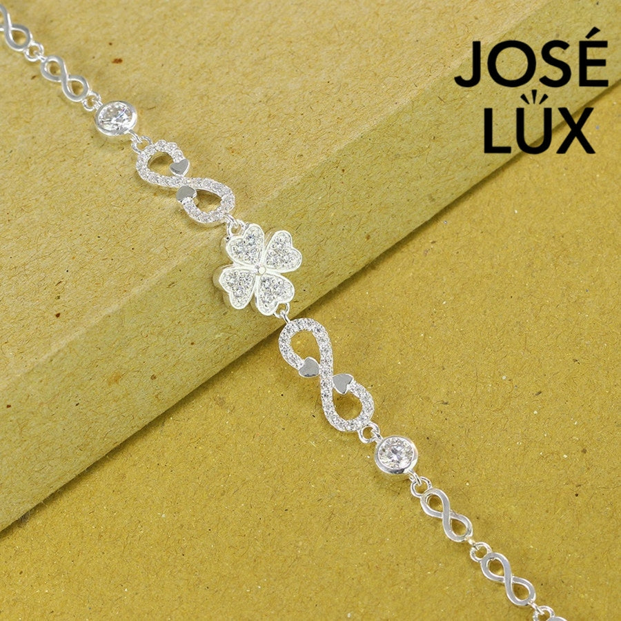Infinity link moissanite bracelet in sterling silver showcases clover centerpiece with two brilliant stones totaling 0.68 carats on symbolic endless chain design.